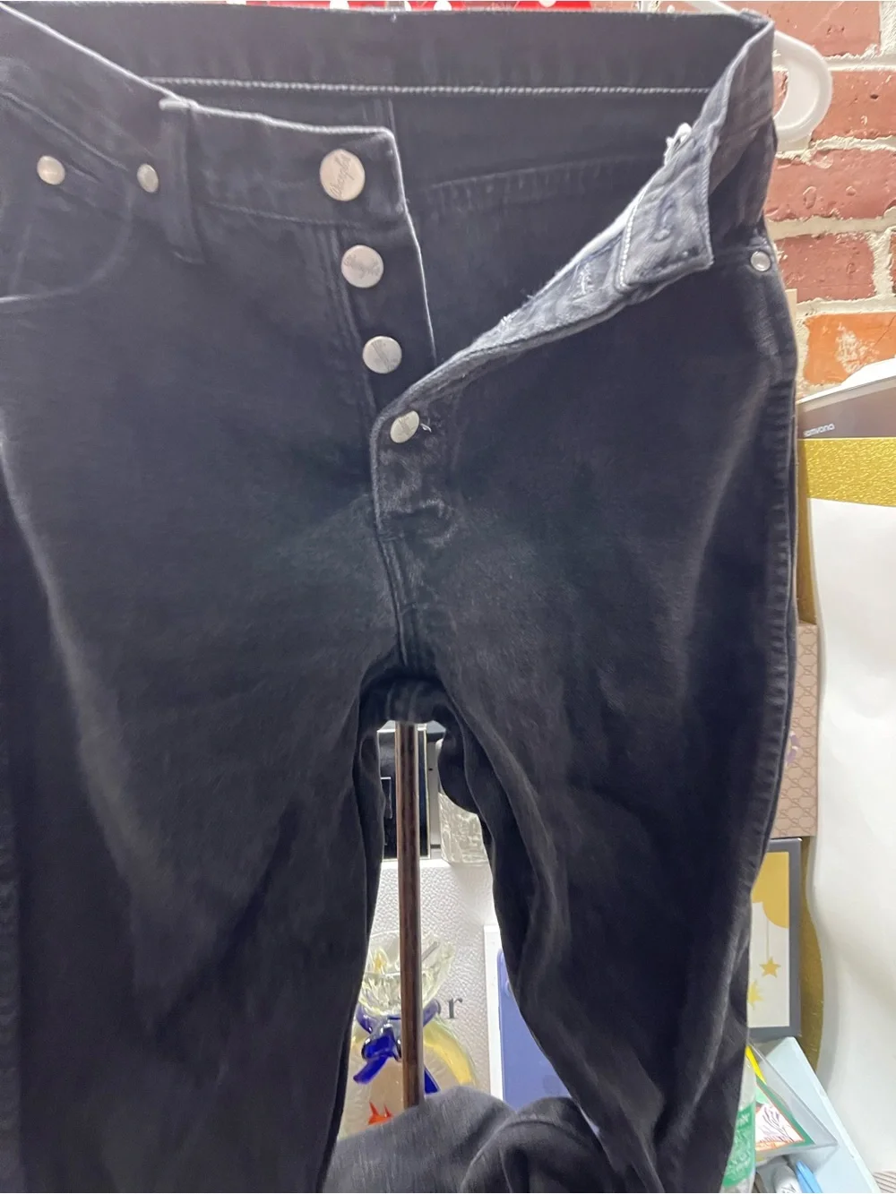 Vtg black Wrangler denim jeans featuring branded silver-tone metal buttons.